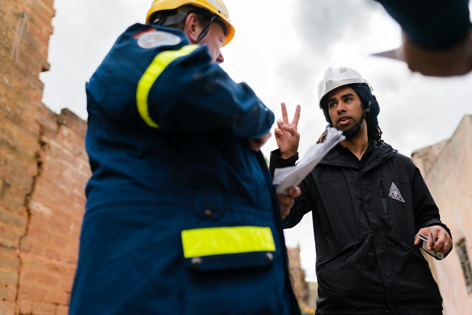 تصميم مخططات الدفاع المدني واعتمادها man in black jacket standing beside woman in yellow jacket