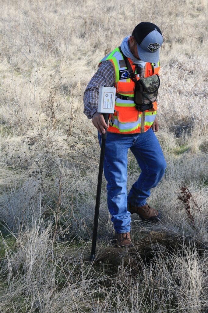 man in orange and black backpack and blue denim jeans standing on brown grass field duringقرار مساحي: أهمية الخدمة المقدمة من كاد آرت للاستشارات الهندسية